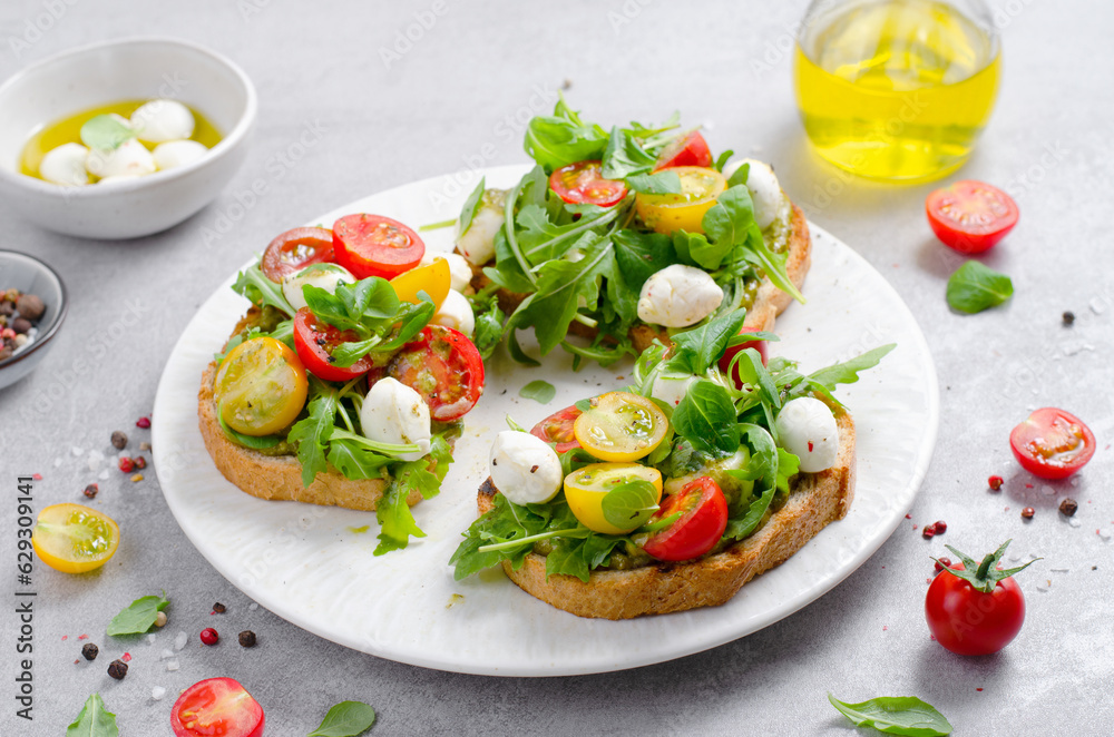 Bruschetta with Cherry Tomatoes, Mini Mozzarella Cheese and Pesto Sauce, Caprese Toasts Bruschetta with Cherry Tomatoes, Mini Mozzarella Cheese and Pesto Sauce, Caprese Toasts