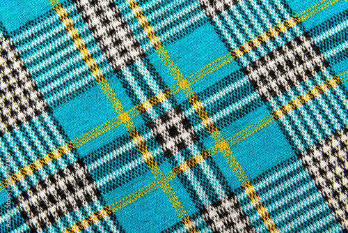 Texture of checkered blue fabric.Textile with intersecting white, black, yellow, blue lines. Pattern. Cell