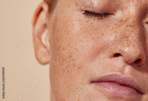 Cropped shot of the face of a young woman with freckles photo