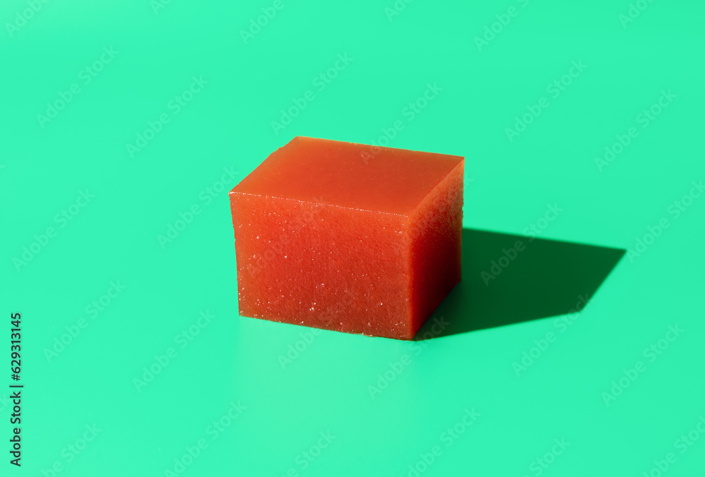 Quince marmalade cube isolated on a green background Quince marmalade cube isolated on a green background