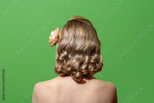 Portrait of a blonde woman with curly hair in retro style, isolated on a green background