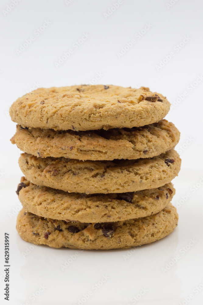 Wheat flour cookies with cherries and chocolate are on a white plate. Close-up. Wheat flour cookies with cherries and chocolate are on a white plate. Close-up.