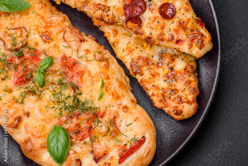 Delicious oven fresh flatbread pizza with cheese, tomatoes, sausage, salt and spices
