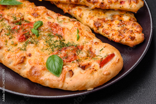 Delicious oven fresh flatbread pizza with cheese, tomatoes, sausage, salt and spices