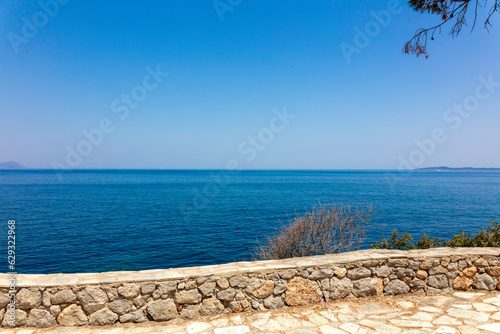 Grecja, niebieskie morze, żaglówki, zabytkowe miasteczka i romantyczne uliczki. Piękne wakacyjne widoki. Wakacje na greckich wyspach.