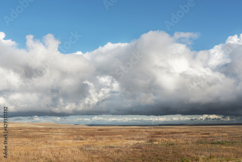 View of an old abandoned road in the steppe beautiful landscape with clouds. Freedom and travel.