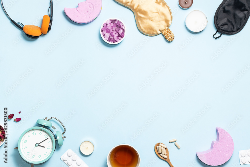 Insomnia concept. Alarm clock, sleeping mask, herbal tea, aromatic salt and natural pills on light blue background top view. 