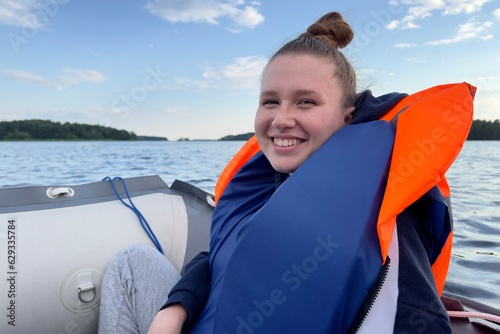 Happy young woman traveler in life vest floating in boat on rippling river © Евгений Шемякин