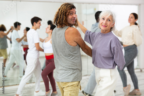 Caucasian man and mature woman learning paired latin dances