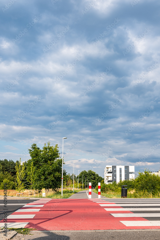 Droga rowerowa o letniej porze w obszarach podmiejskich zachodniej Polski w tle błękitne pochmurne niebo - obrazy, fototapety, plakaty 