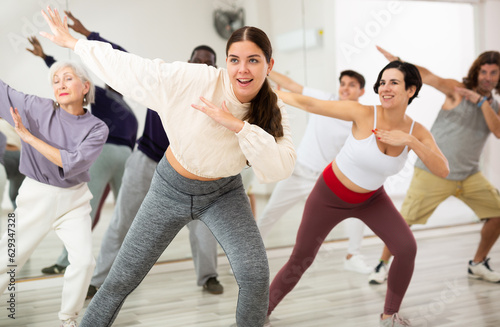 Group of adult people practices dance aerobics in class in the dance studio