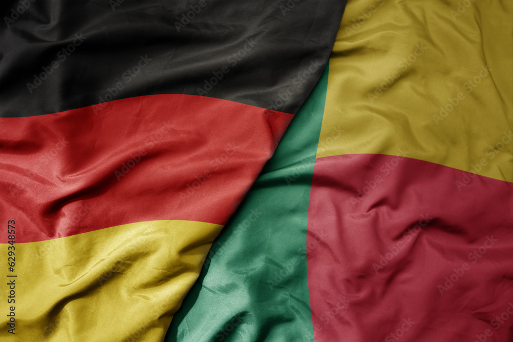 big waving realistic national colorful flag of germany and national flag of benin .