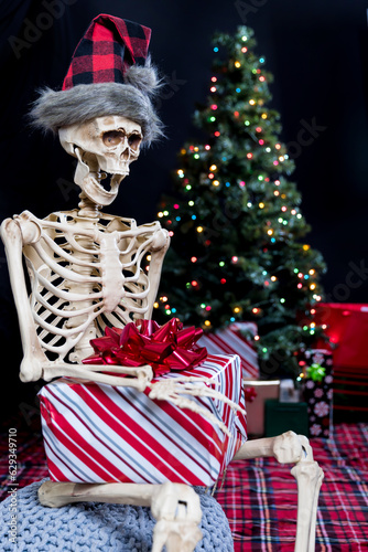 Skeleton excited on Christmas morning ready to open a present