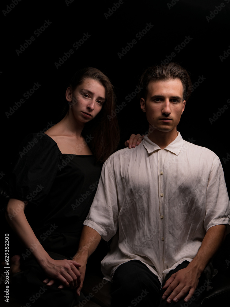 Obraz premium young couple white brunette man and white brunette woman with long hair on a dark background