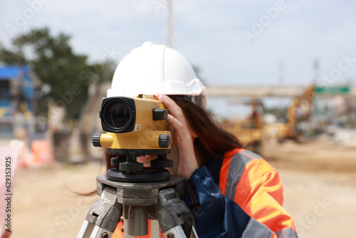 Portrait of a beautiful engineer woman at the construction site with the survey instrument