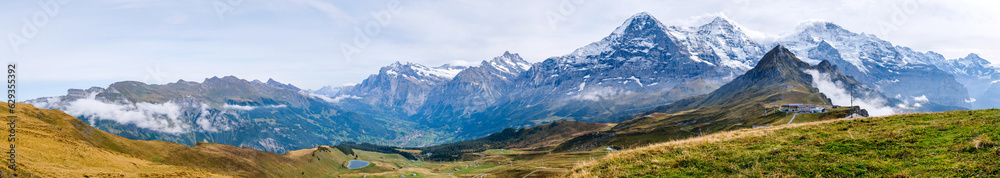 Wide panorama of Grindelwald valley and Swiss Alps. Mountain range of peaks Eiger, Wetterhorn, Schreckhorn, Monch, Jungfraujoch and Jungfrau from Mannlichen near Wengen and Lauterbrunnen, Switzerland Wide panorama of Grindelwald valley and Swiss Alps. Mountain range of peaks Eiger, Wetterhorn, Schreckhorn, Monch, Jungfraujoch and Jungfrau from Mannlichen near Wengen and Lauterbrunnen, Switzerland