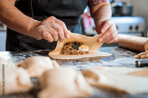 Latin Elderly Woman Making Chilean Baked Empanadas in the Authentic Ambience of her Countryside Home Kitchen. Close up
