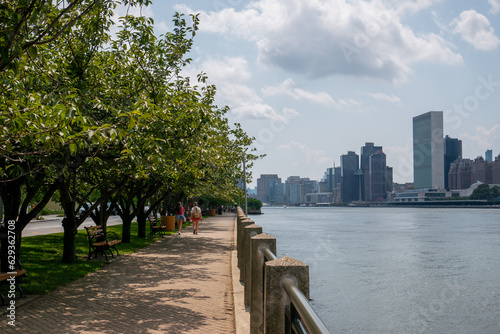 River side path next to the East River on Roosevelt Island in New York, on the right United Nations headquarters are visible in Manhattan.