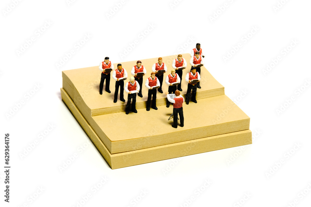 Creative miniature people toy figure photography. Sticky notes installation. Boys student doing choir performance on stage. Isolated on white background Creative miniature people toy figure photography. Sticky notes installation. Boys student doing choir performance on stage. Isolated on white background