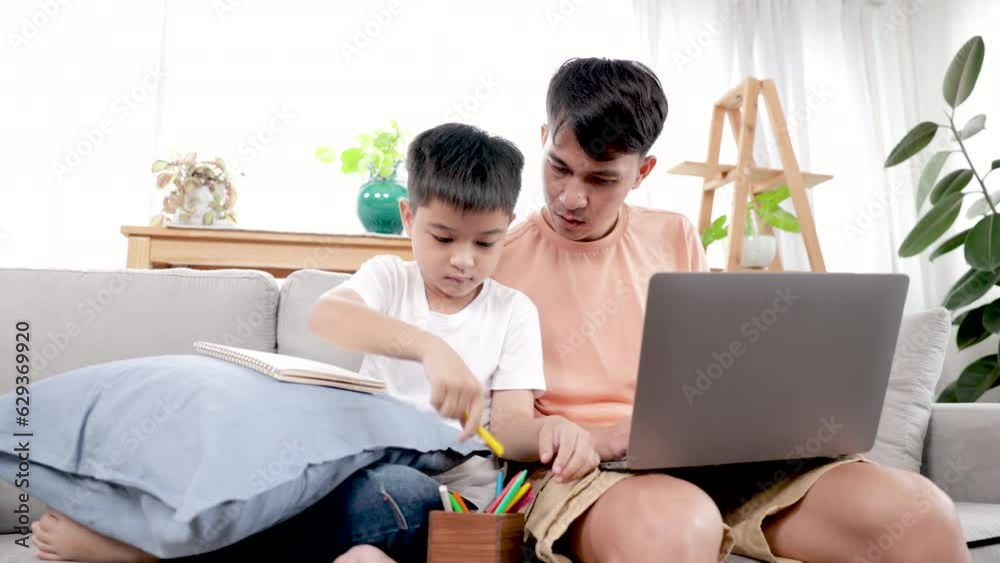 family or parenthood activities at home concept, father in casual working on laptop taking care adorable son, multitask father lifestyles with kid, Asian boy sit close to dad painting on paper family or parenthood activities at home concept, father in casual working on laptop taking care adorable son, multitask father lifestyles with kid, Asian boy sit close to dad painting on paper