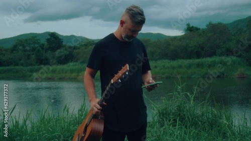 guitarist is using his smartphone outdoors photo