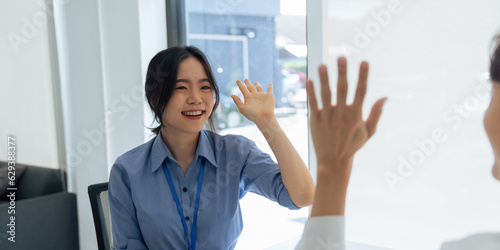 Business teamwork office worker gives high fives to a male colleague, celebrating project success