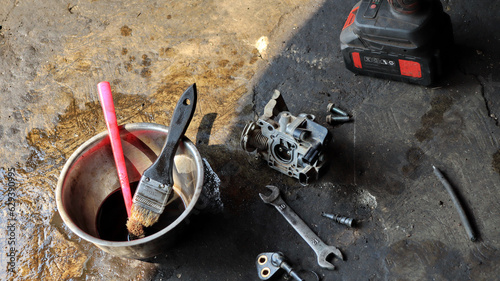 The local mechanic cleans the motorcycle carburetor with gasoline photo