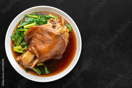 Chinese stewed pork knuckle leg in sweet brown sauce on dark tone texture background with copy space for text, top view, flat lay, Thai food, Ka Moo Pa Lo, Ka Moo Palo, Kha Moo Pa Lo, Kha Moo Palo