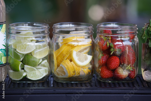 Lime, lemon and strawberries in jars