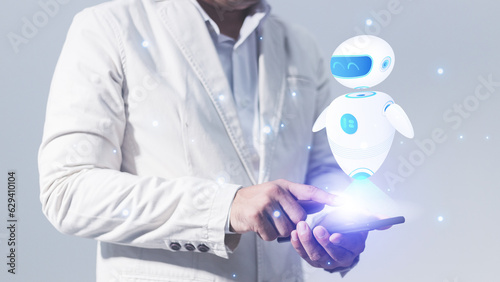 Businessman holding a tablet with a robot hologram on the screen
