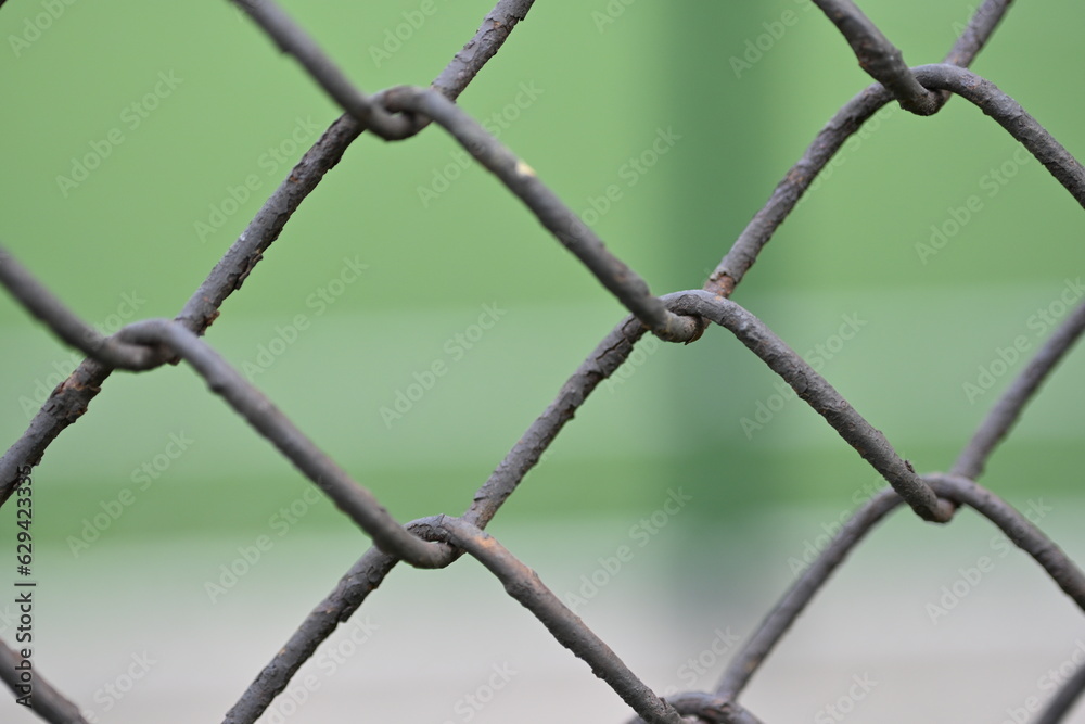 iron mesh close-up against the background of a green stadium iron mesh close-up against the background of a green stadium