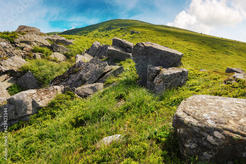 green hills and meadow in mountains. stones among the grass beneath a sky with clouds. summer vacations in ukraine