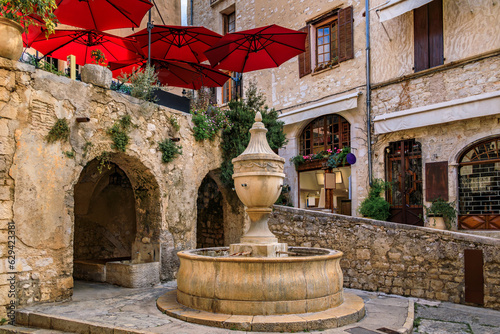 Fototapeta Naklejka Na Ścianę i Meble -  Traditional old stone fountain on a central square in the medieval town of Saint Paul de Vence, French Riviera, South of France