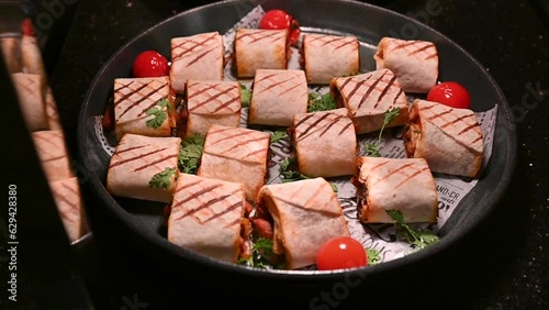 Chicken shawarma pieces stuffed with barbecue sauce under a hot plate photo