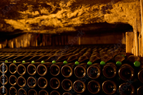 Wine bottles aging in caves in France at Monmousseau winery photo