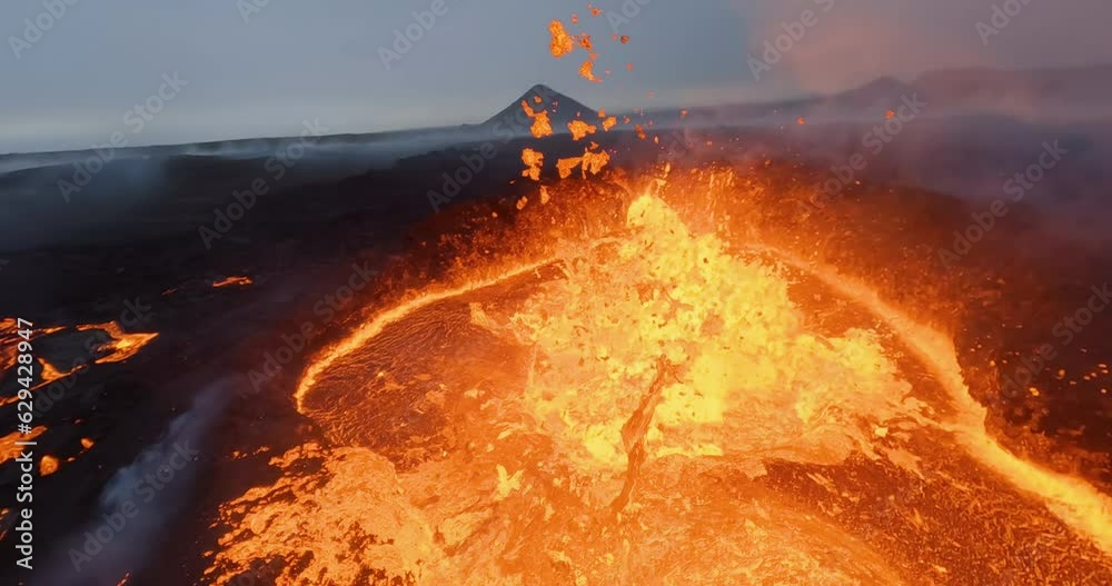 Through a splattering lava outburst inside a volcano crater - FPV Aerial view