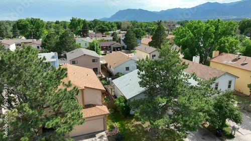 Houses in Colorado neighborhood. Aerial rising shot revealing large housing development with view of Rocky Mountains in distance.