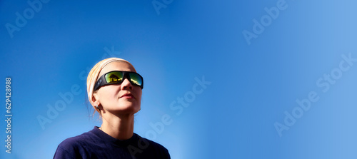 Active woman hiker close up portrait against blue sky. Showing peaks of Mount Elbrus in glasses. Mount Elbrus, Caucasus. International Mountain Day, Mountaineering day, Climber's day © Olivia