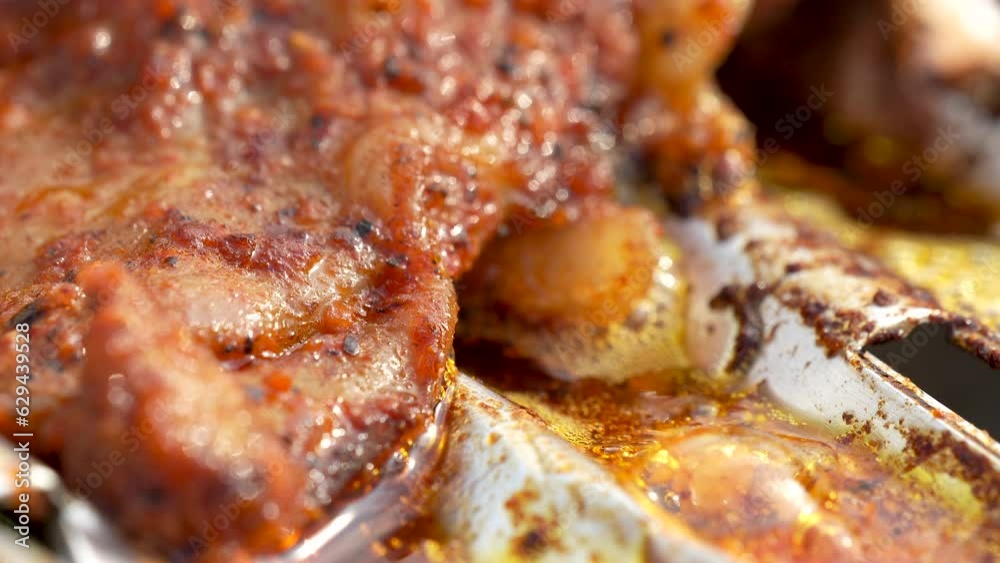 Marinated Chicken Meat Drilled on Barbecue Metal Grid, Bubbling Hot Oil Close-up. Preparation of fast food. Unhealthy food with trans fats