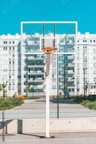 Transparent plexiglass basketball backboard with hoops on outdoor court for streetball in urban residential district