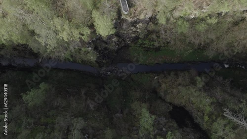 Top down view aerial drone shot of narrow Corrieshalloch gorge surrounded by forest in Scottish Highlands photo