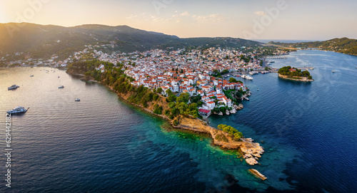 Panoramic view of the old harbor and town of Skiathos island, Sporades, Greece, with Bourtzi peninsula and Plakes area in front during sunset time photo