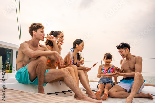 Group of diverse friends eating barbecue while having a party in yacht.  © Kawee