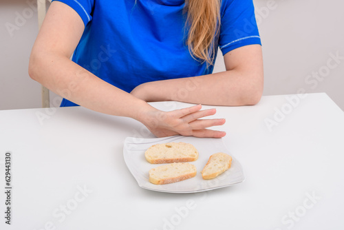 Dziewczyna odsuwająca od siebie talerz jedzeniem