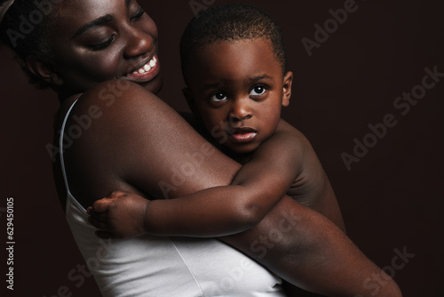 Black young woman laughing and holding her son