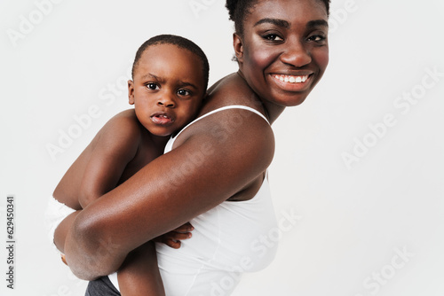 Black young woman laughing while playing and holding her son