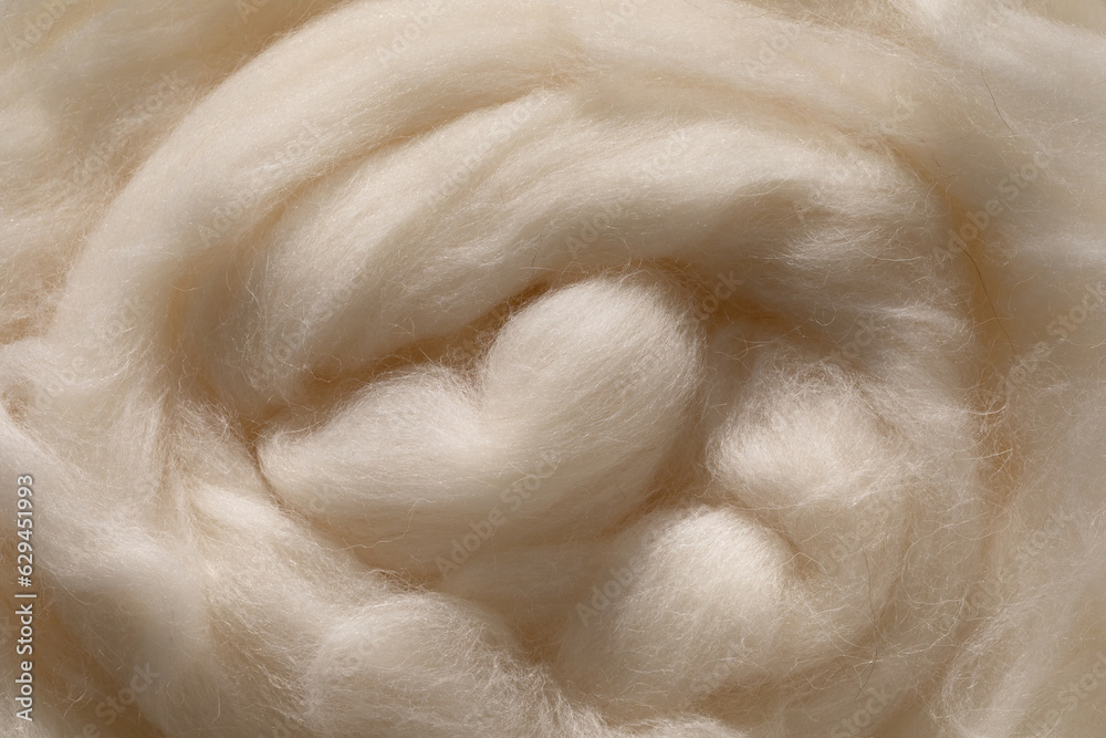 Fluffy woolen fiber in neutral beige color as background. Natural material in aesthetic sunlight. Fluffy woolen fiber in neutral beige color as background. Natural material in aesthetic sunlight.