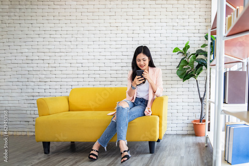 Happy young asia teenager girl checking social media on mobile phone , Smiling young woman using app shopping online and orderingdelivery