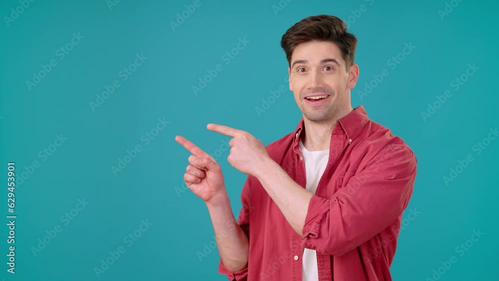 Enthusiastic man points fingers to side drawing attention Enthusiastic man points fingers to side drawing attention