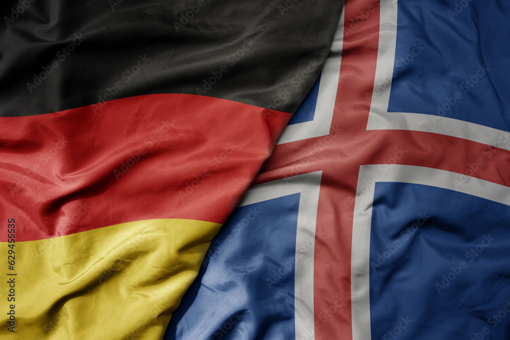 big waving realistic national colorful flag of germany and national flag of iceland .